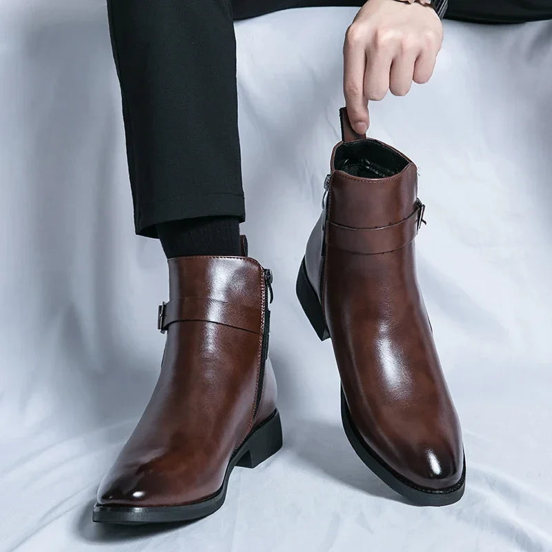 Person wearing polished dark brown leather ankle boots with side buckles, pull tabs, and block heels.