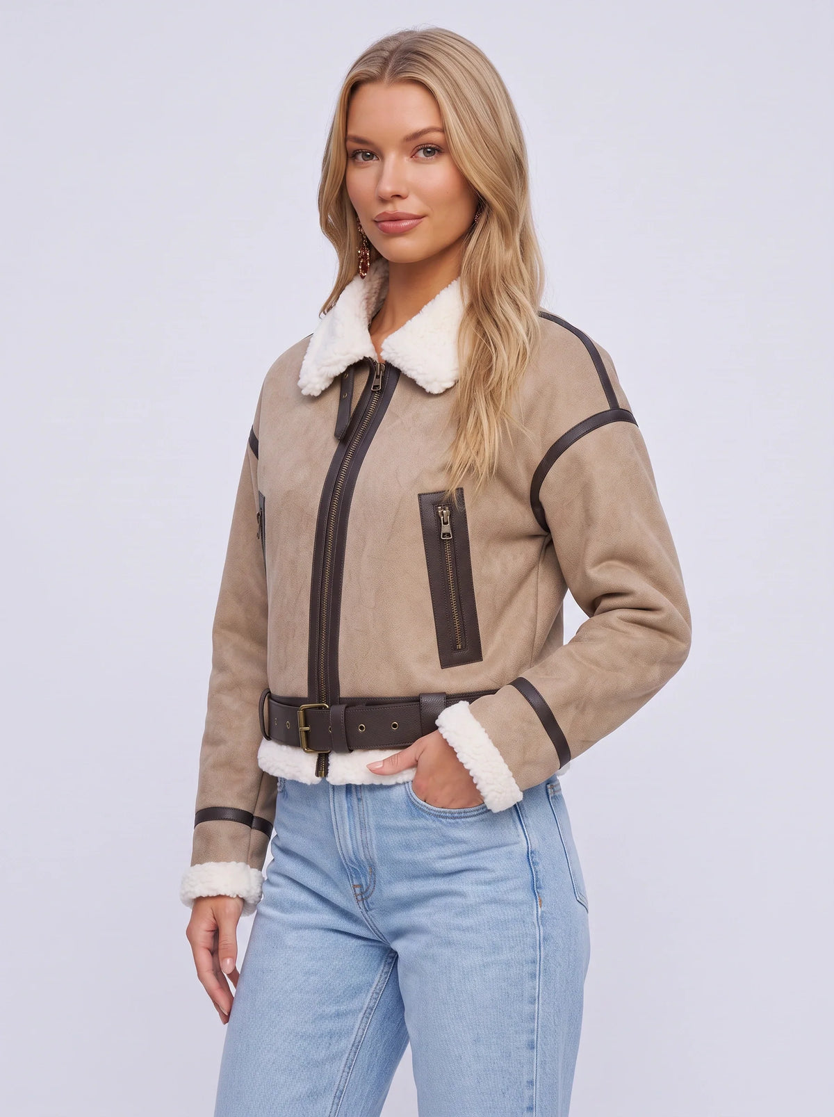 A woman wearing a beige leather shearling aviator jacket with a cropped fit, shearling collar, and belted waist, front view