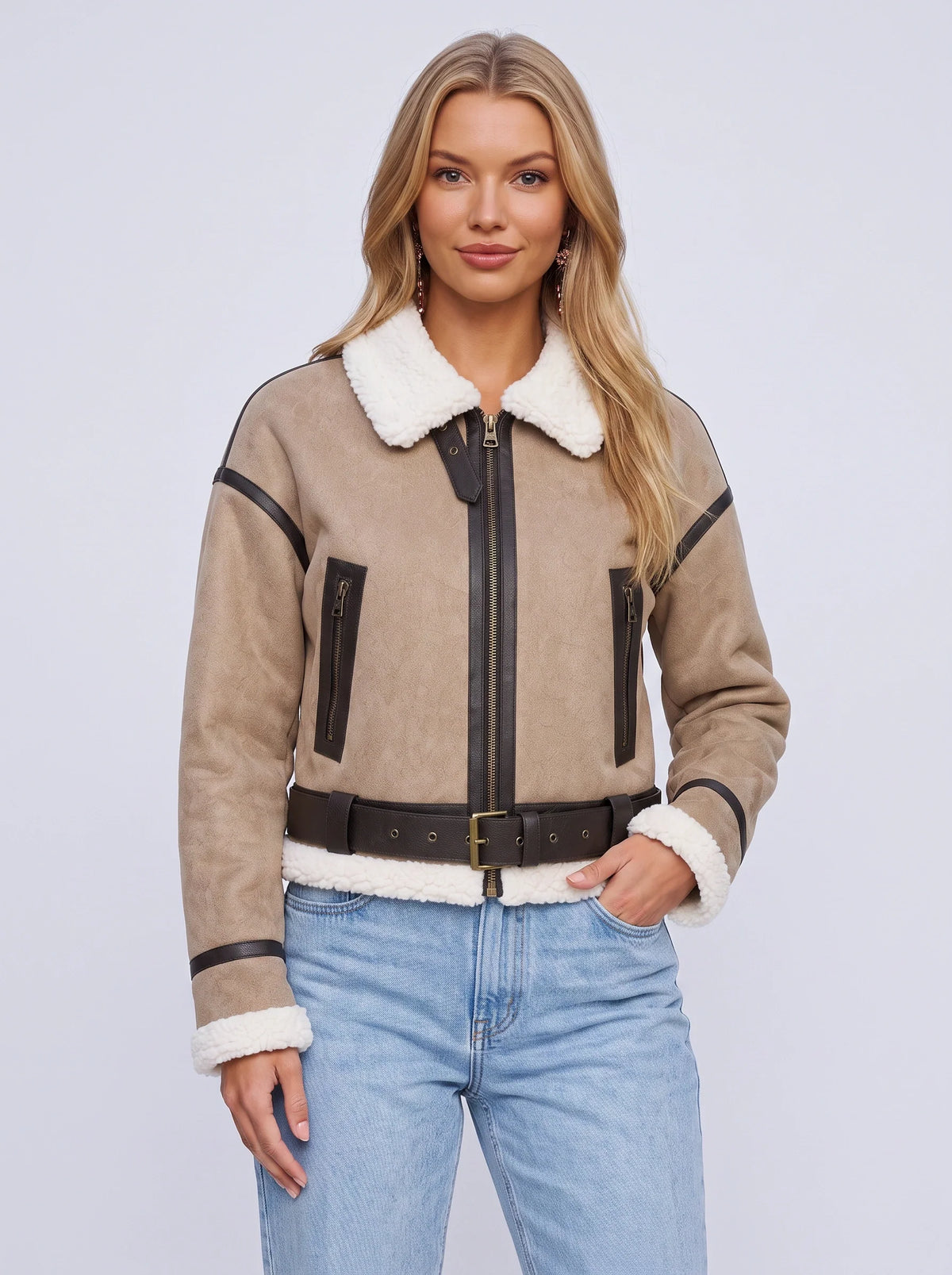A woman wearing a beige leather shearling aviator jacket with a cropped fit, shearling collar, and belted waist