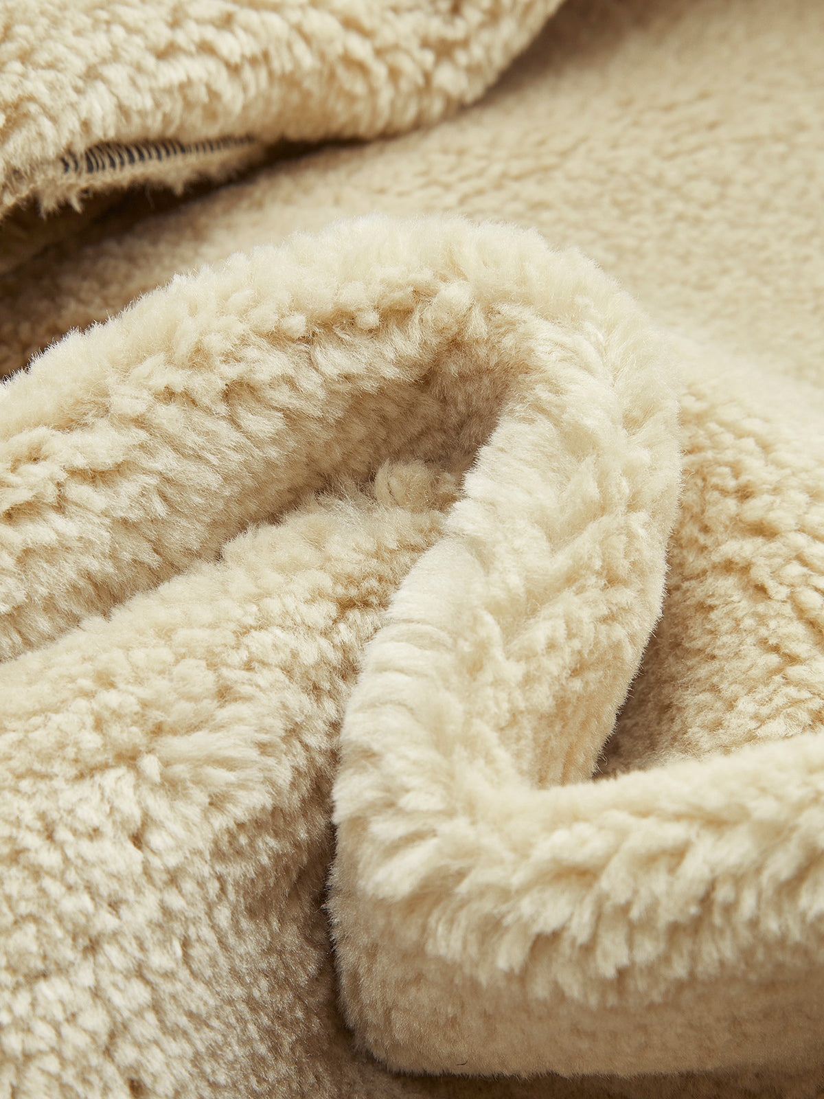 Close-up of the plush shearling lining inside a black leather aviator jacket