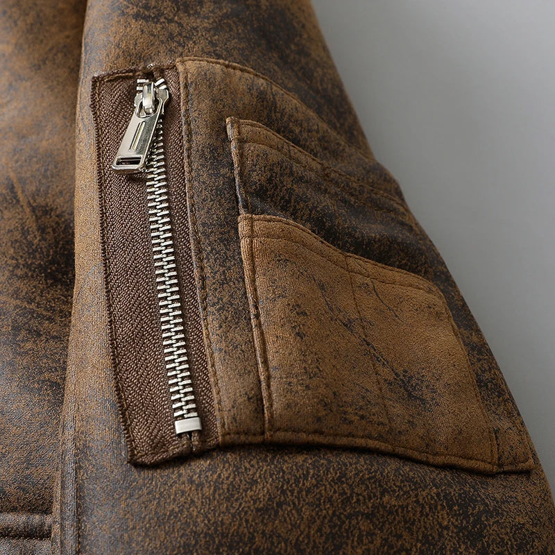 Close-up of a brown leather shearling jacket showing the zippered pocket and plush lining