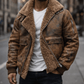 A man wearing a brown leather shearling jacket with plush lining, a wide shearling collar, zip front, and ribbed cuffs