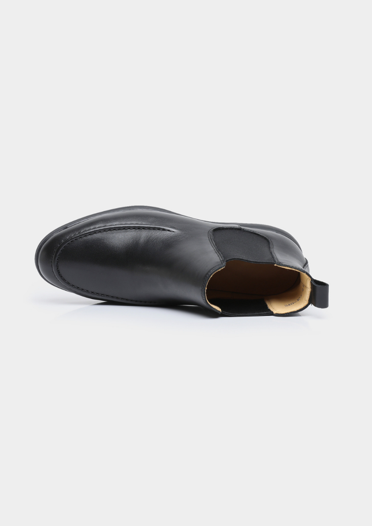 Black Chelsea boot showing the opening, elastic side panel, and pull tab.