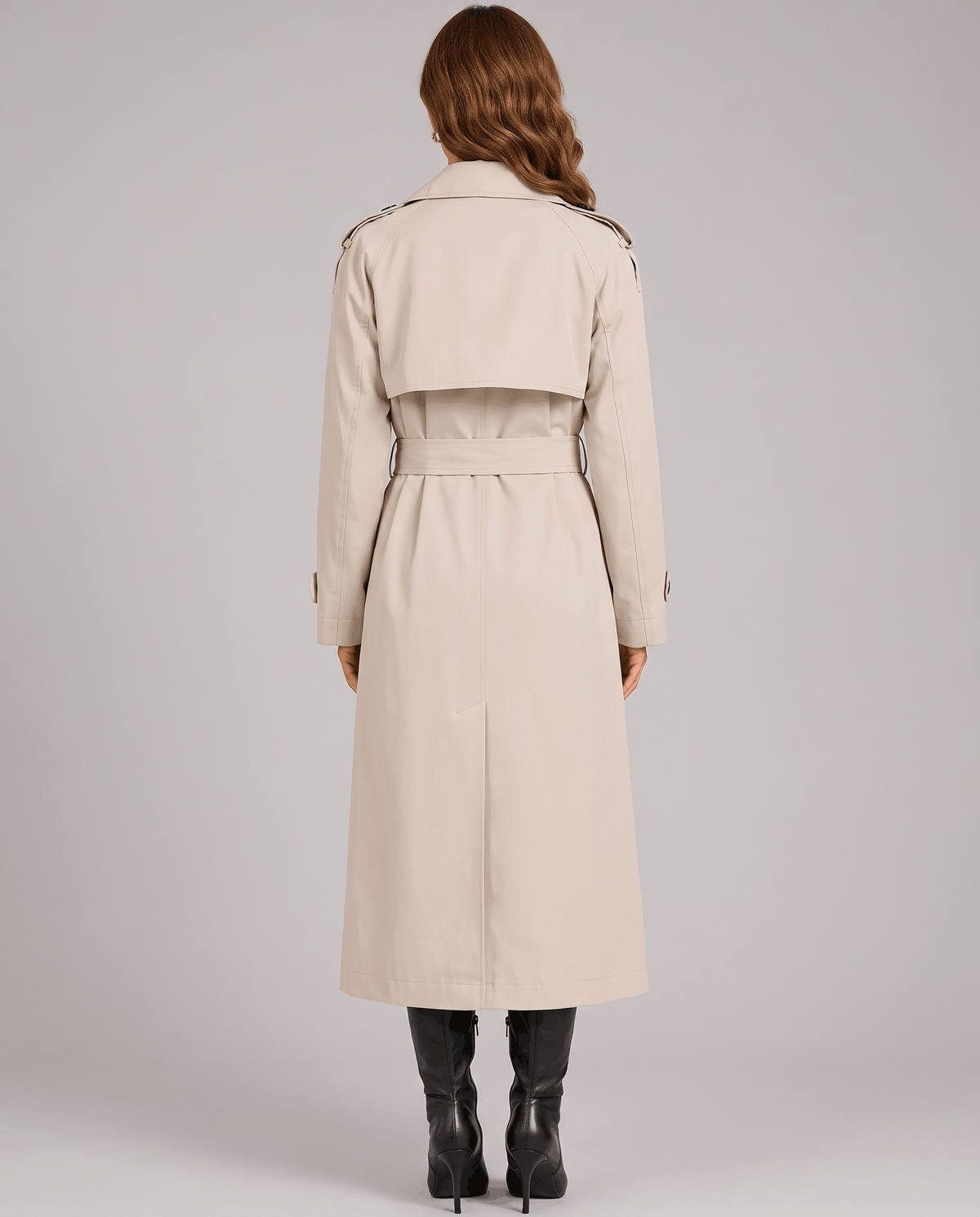 A woman wearing a cream long trench coat with a double-breasted front and belted waist, shown from the back