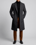 A man wearing a charcoal gray long wool overcoat with a notch lapel and single-breasted fit