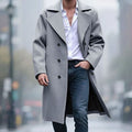A man wearing a light gray long wool trench coat with a double-breasted front and sharp notch lapel, walking outdoors