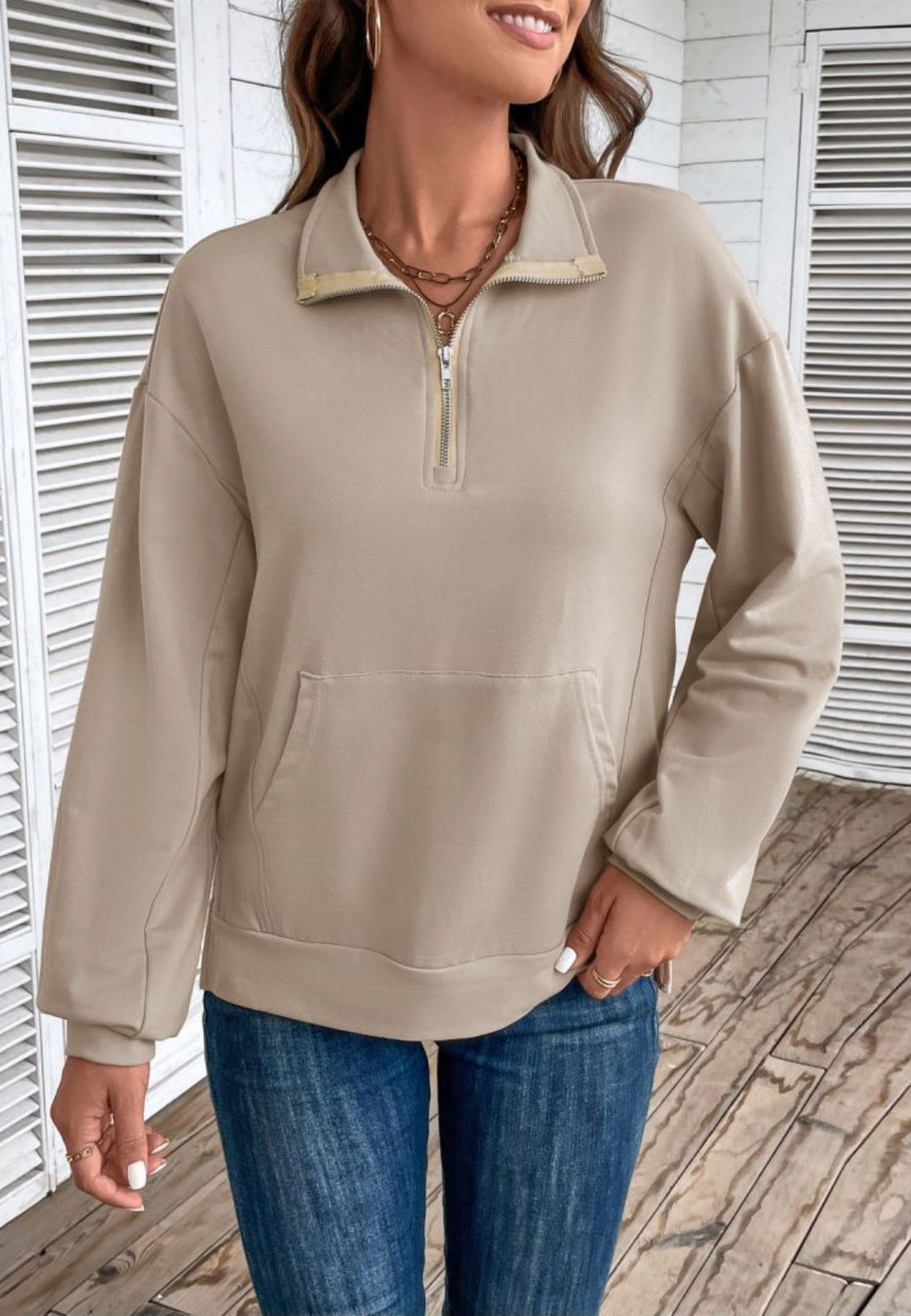 Taupe loose fit quarter-zip sweater worn by a female model, front view