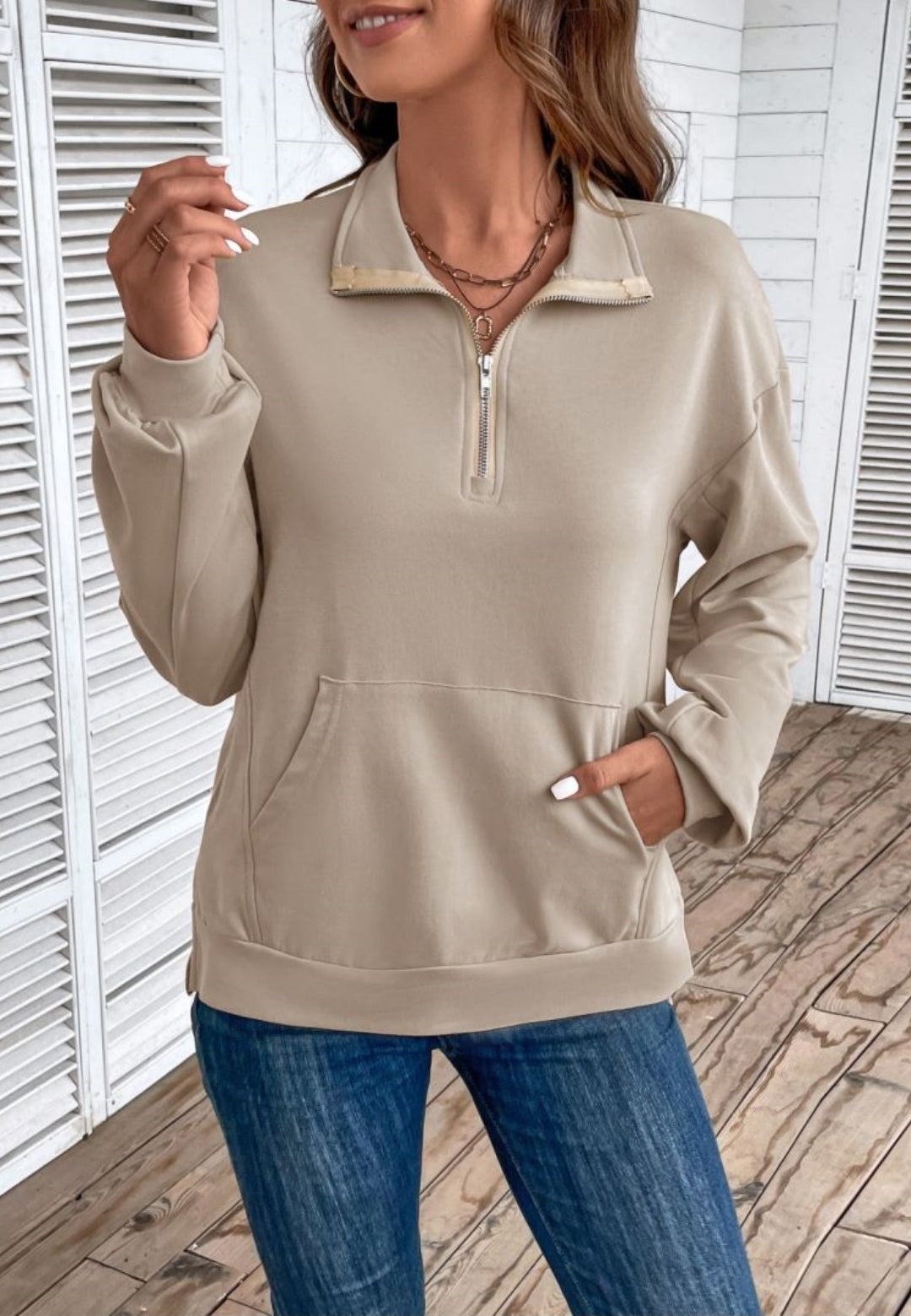 Taupe loose fit quarter-zip sweater worn by a female model, front view