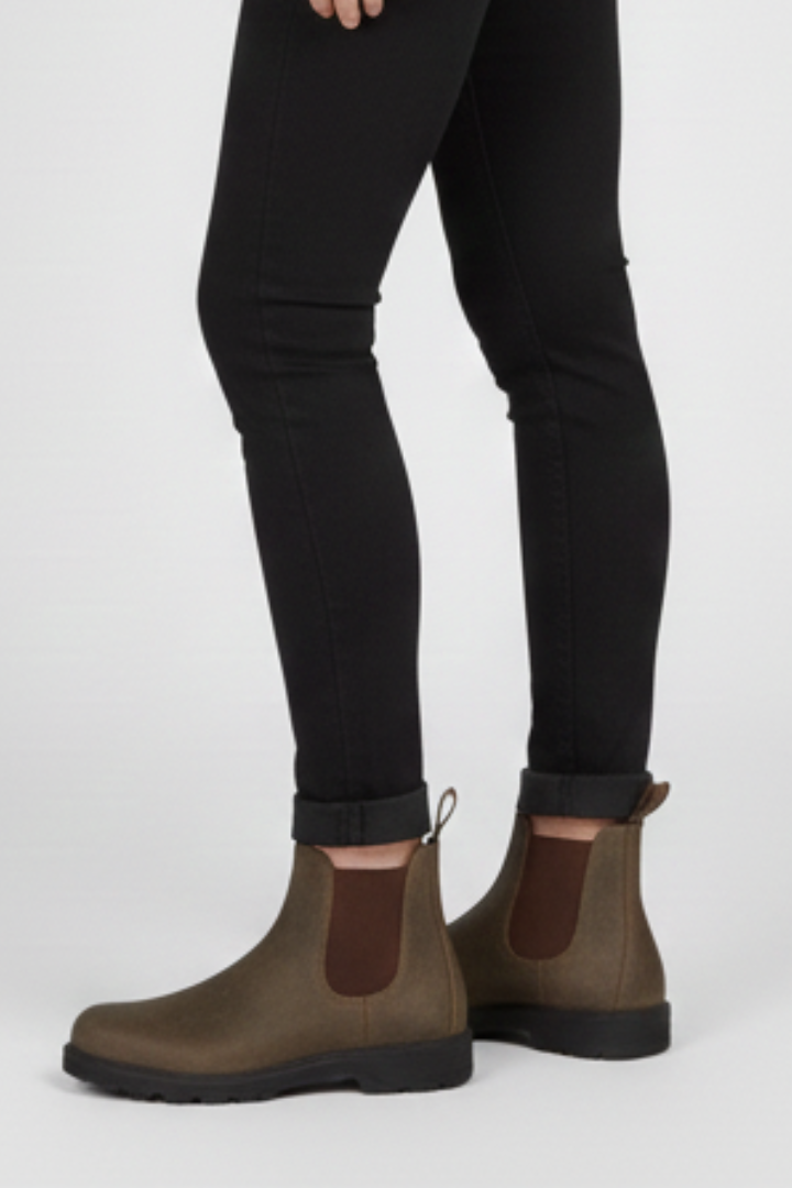 Brown lug sole Chelsea boots for women worn with black skinny jeans, full side view of both boots