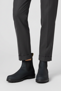Black leather lug sole Chelsea boots for women with twin pull tabs, worn with tapered grey trousers