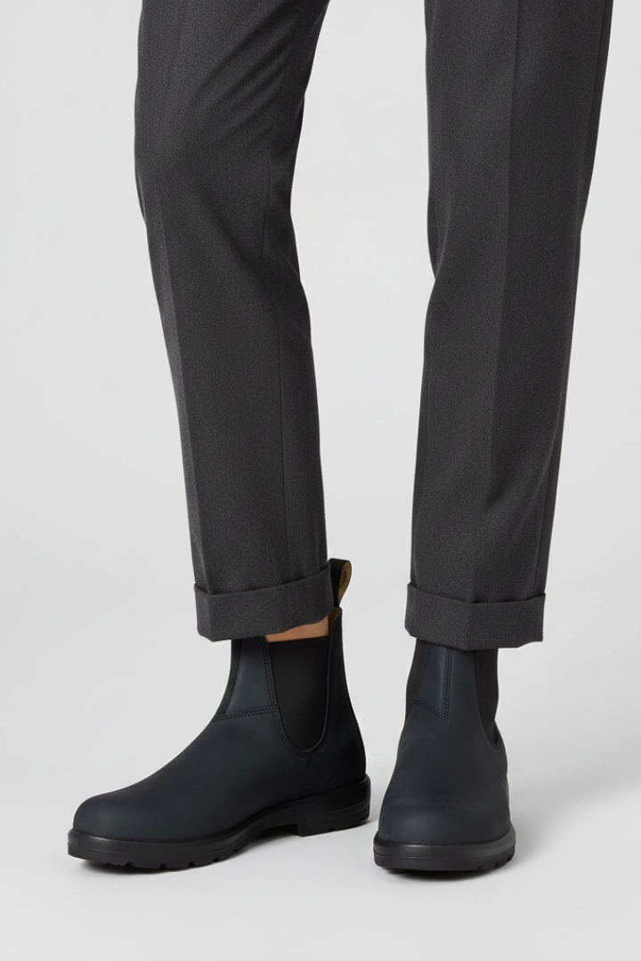 Black leather lug sole Chelsea boots for women with twin pull tabs, worn with tapered grey trousers