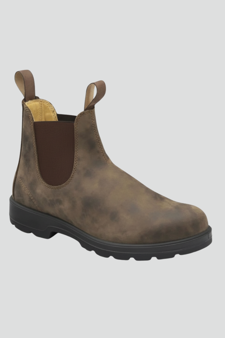 Black leather lug sole Chelsea boots for women worn with cuffed grey trousers, front view