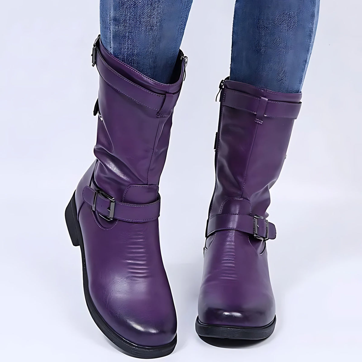 Pair of purple knee-high boots with buckle straps and low block heels.