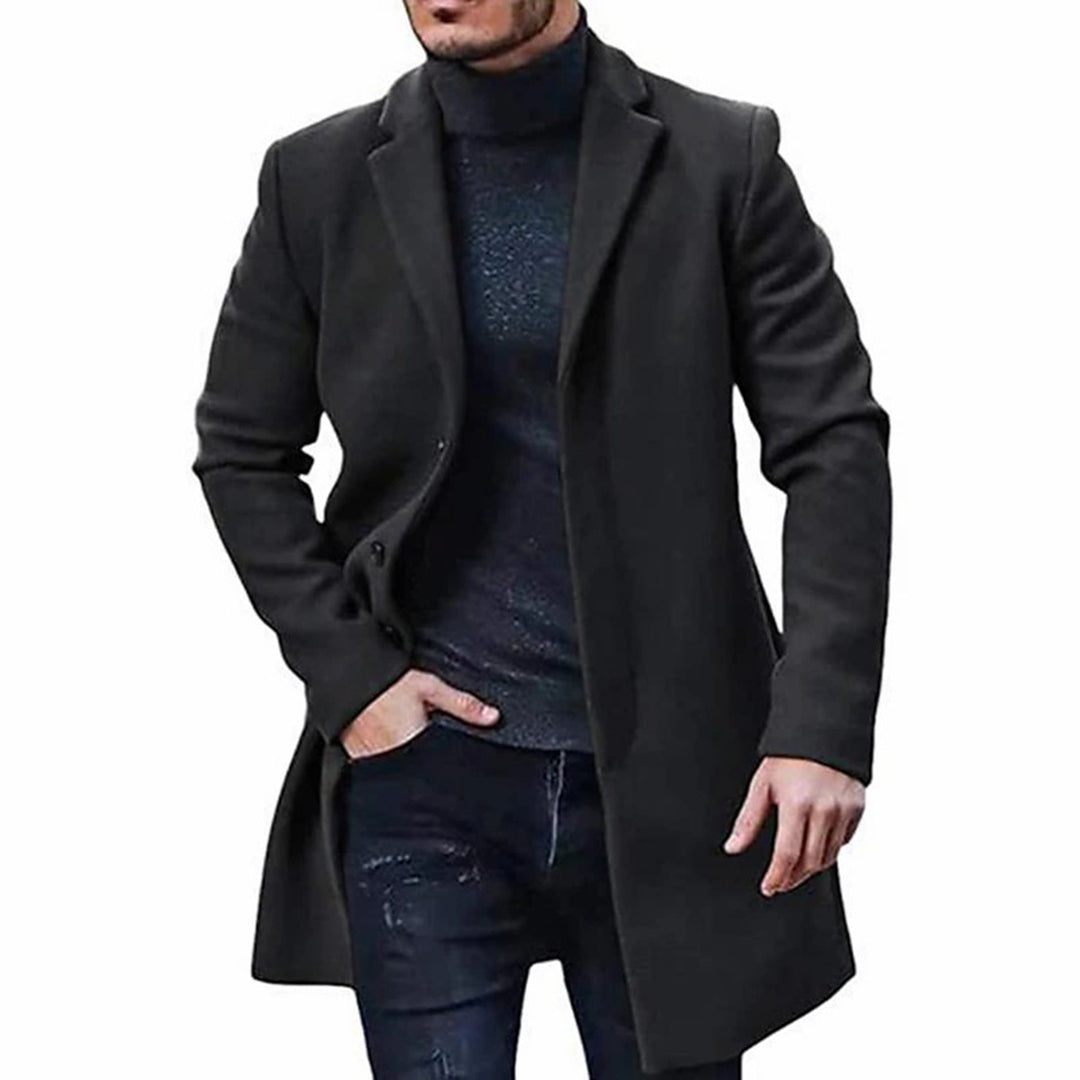 A man wearing a black mid-length wool coat with a single-breasted front and tailored fit