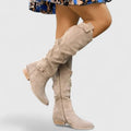 Taupe suede over-the-knee boots with a slouchy shaft, almond toe, side zip, and low block heel.