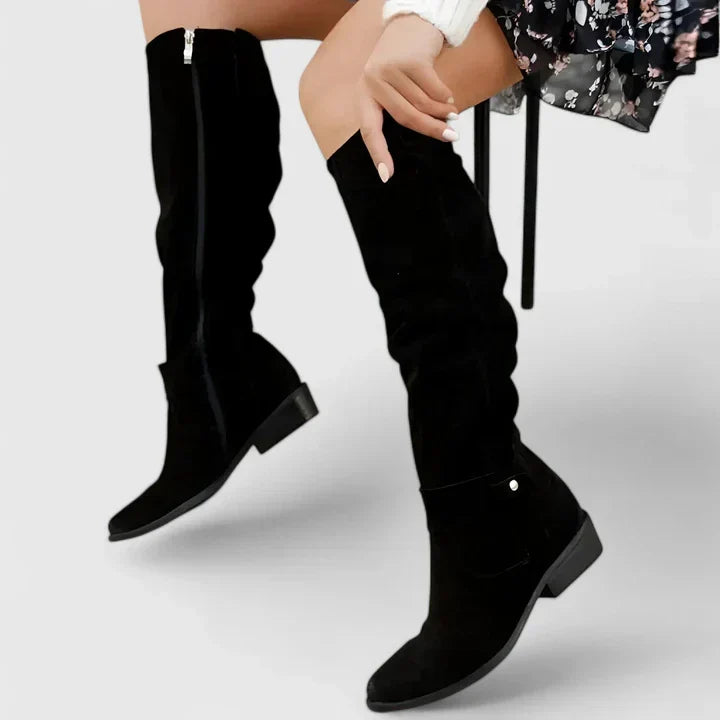 Black suede over-the-knee boots with a slouchy shaft, side zip, almond toe, and low block heel with snap tab detail.