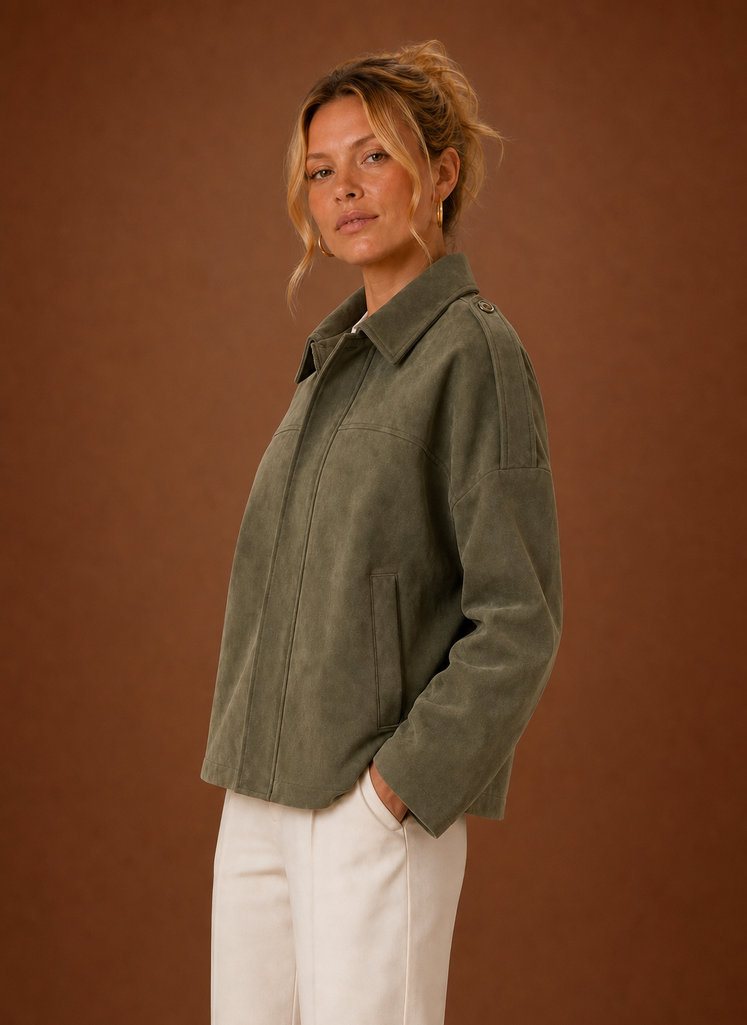 A woman wearing an olive green oversized suede jacket with a boxy fit and long sleeves, side view