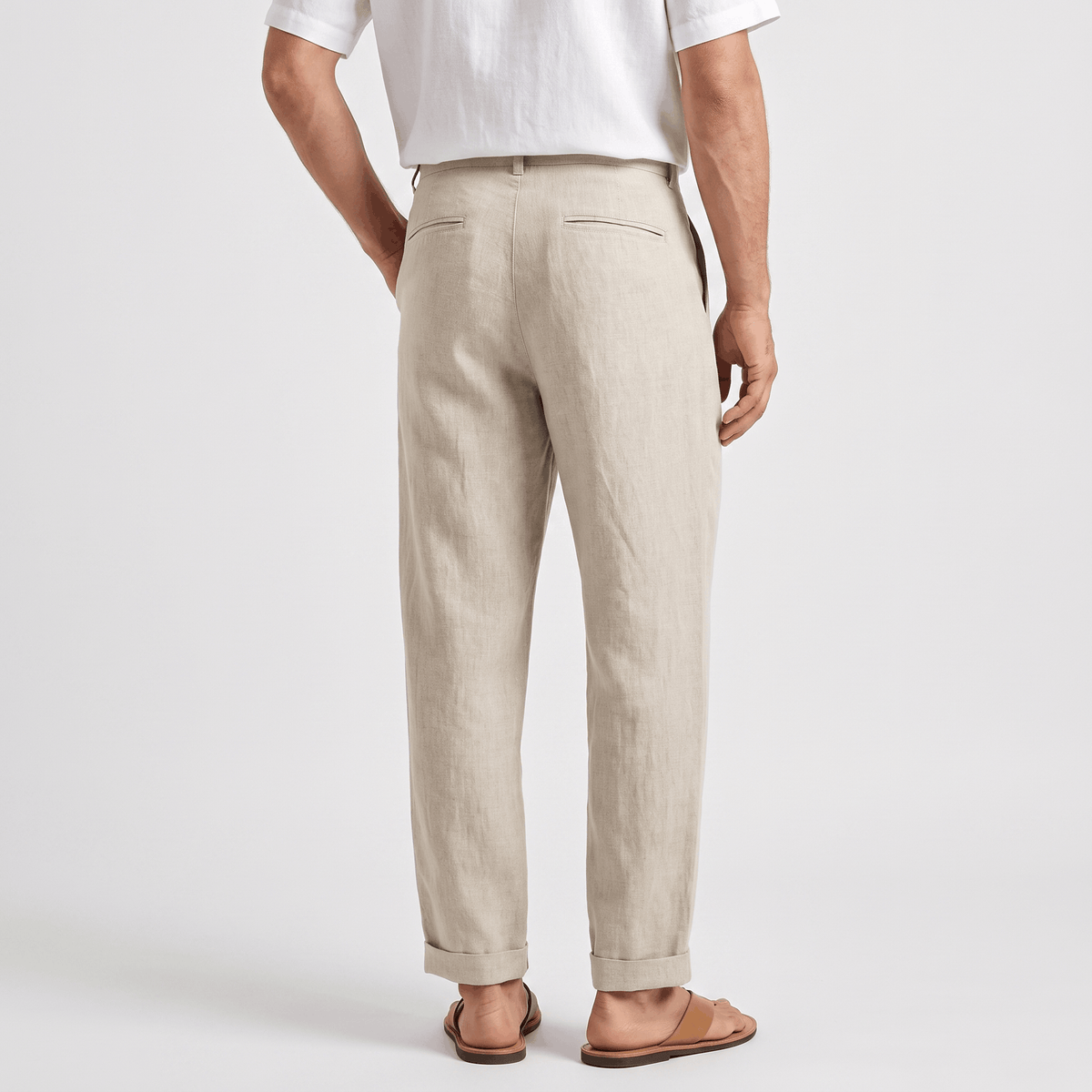 Back view of men's beige linen pants featuring a straight-leg silhouette, belt loops, and breathable linen fabric.
