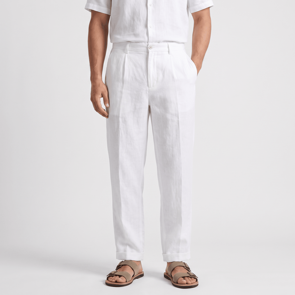 Men's white linen pants featuring a straight-leg fit, button closure, belt loops, and side pockets.