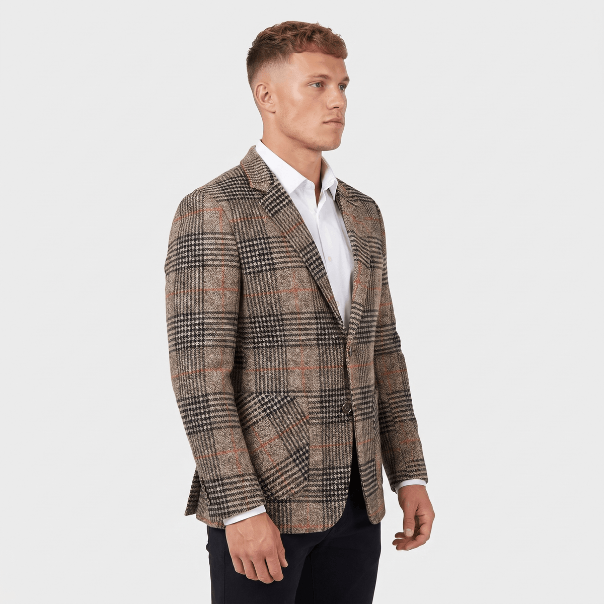 Side view of a man wearing a brown plaid tweed blazer with a notched lapel, button closure, and tailored silhouette.