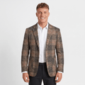 Man wearing a brown plaid tweed blazer with a notched lapel, two-button closure, flap pockets, and tailored fit over a white dress shirt and black trousers.