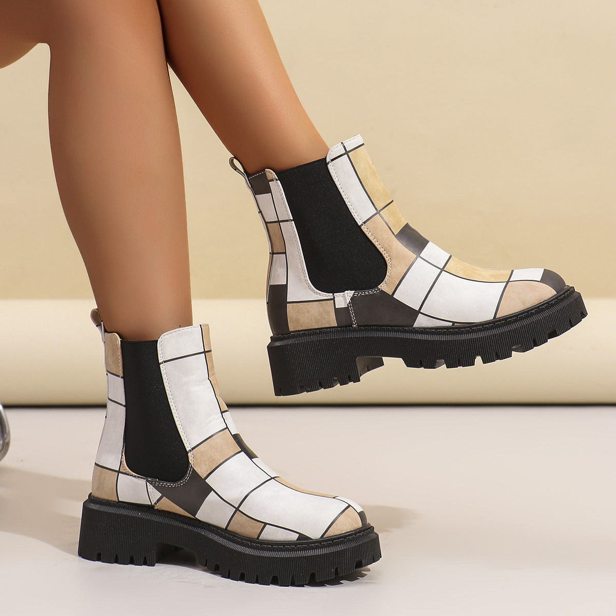 Close-up of white and grey geometric panel Chelsea boots for women with black elastic side panels