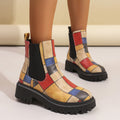 Woman wearing red and tan geometric panel platform Chelsea boots with black elastic side panels and lug sole