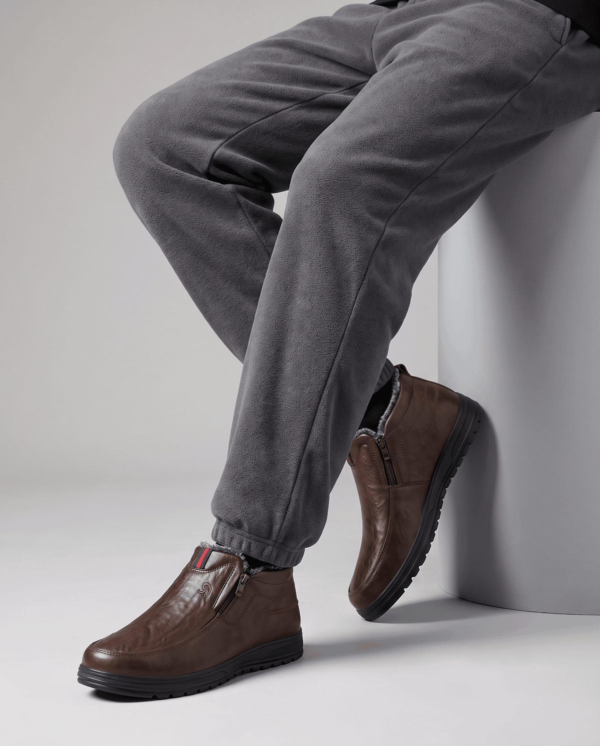 Brown plush-lined slip-on winter boots worn with dark trousers