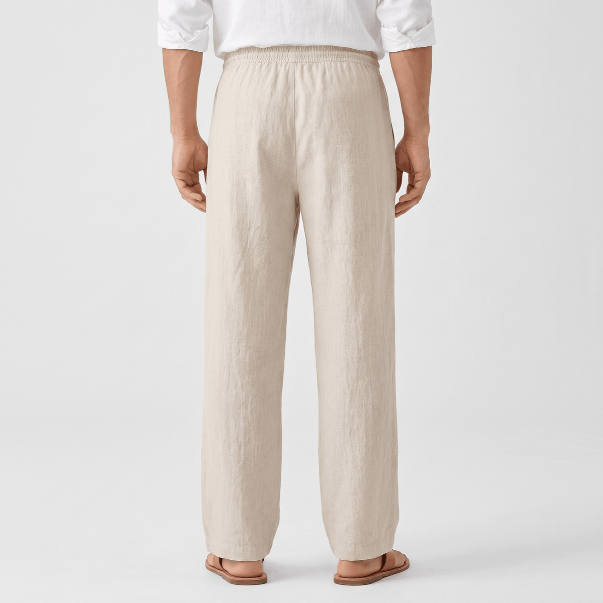 Back view of men's cream linen drawstring pants with an elastic waistband and classic straight-leg silhouette.