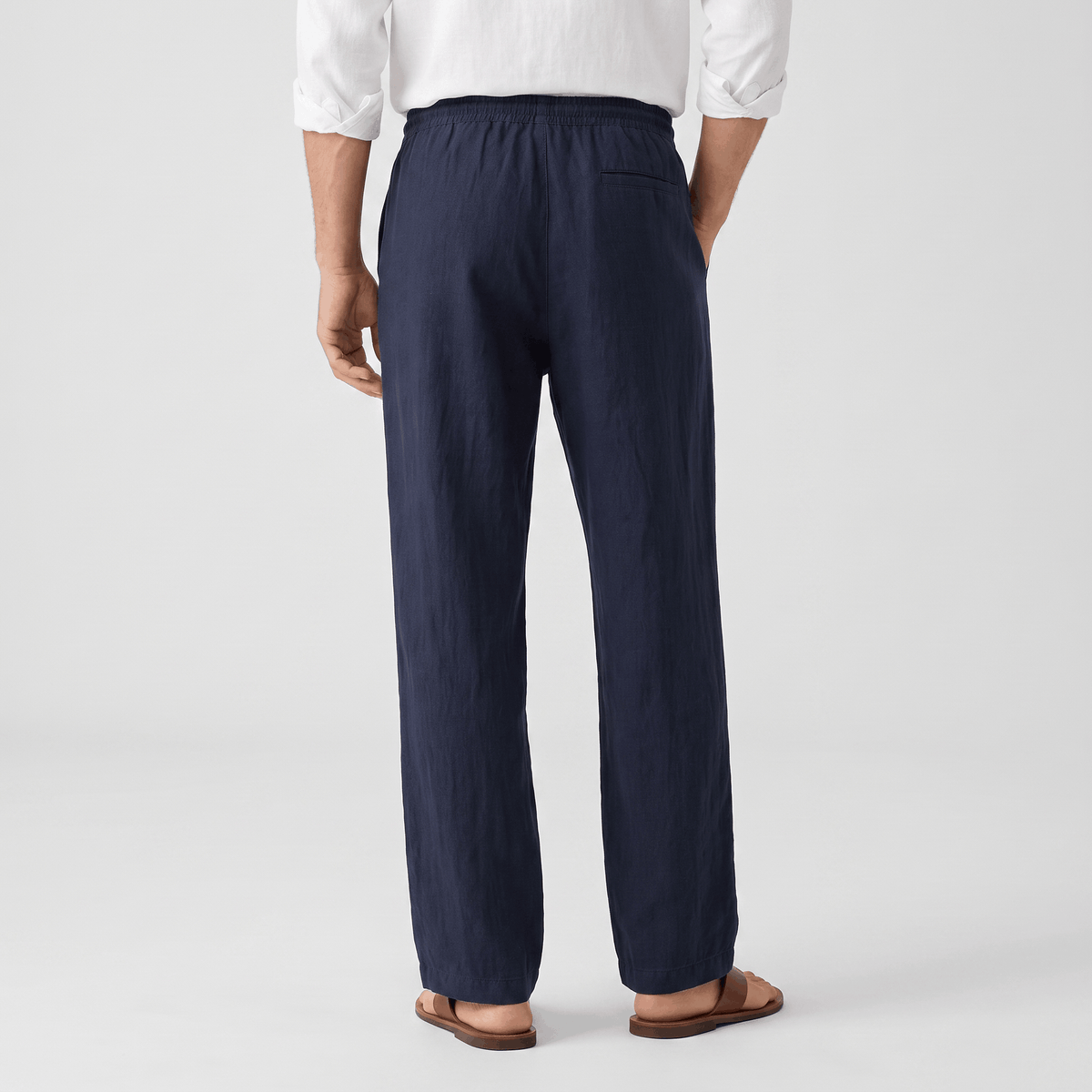 Back view of men's navy linen drawstring pants with an elastic waistband and breathable linen construction.