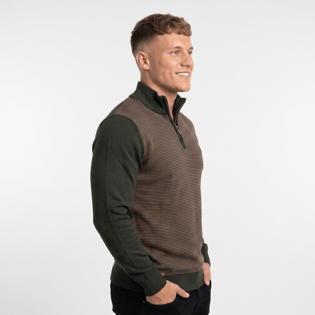 Side view of a man wearing a brown and olive green quarter-zip sweater with ribbed knit construction and stand collar.