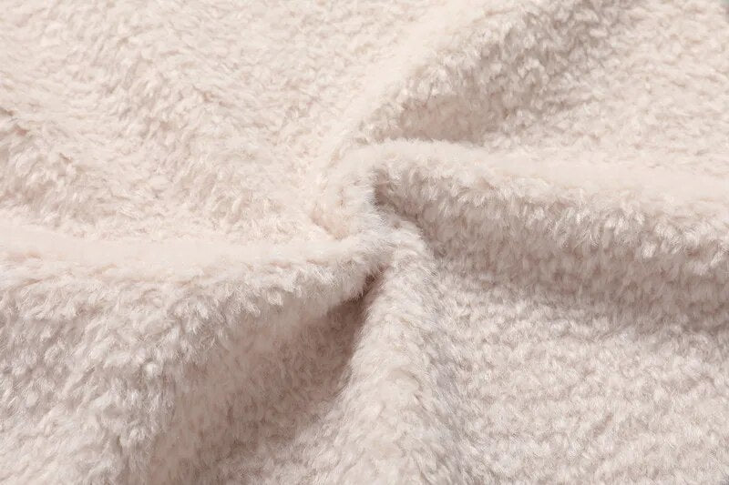 Close-up of the plush lining inside a white shearling leather jacket, showing its soft textured finish