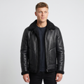 A man wearing a black shearling leather jacket with plush lining, a buckle collar, and full-zip front