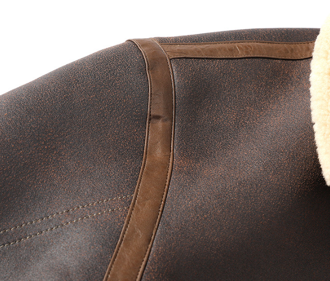 Dark brown aviator jacket close-up showing the leather trim, seam detailing, and sherpa lining