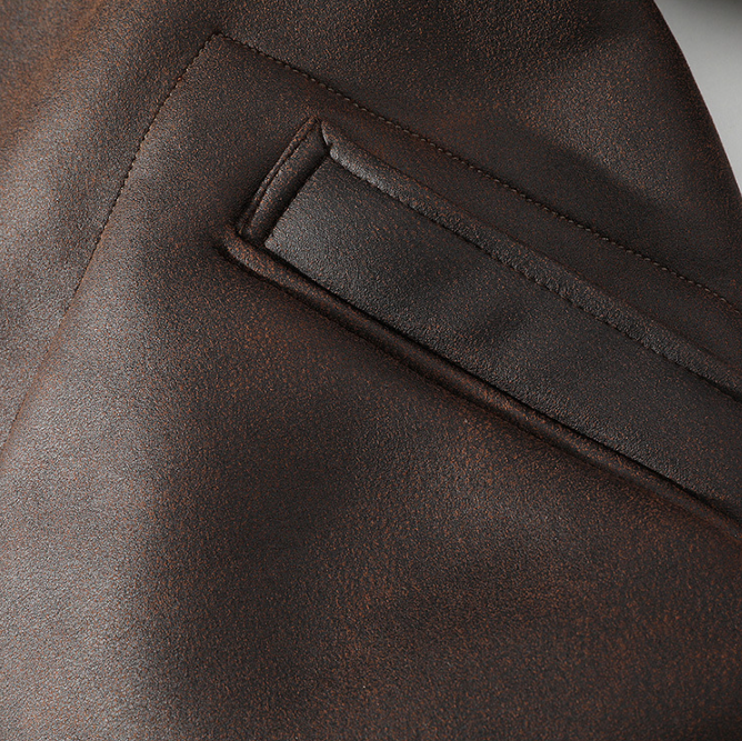 Dark brown aviator jacket close-up showing the zippered front pocket and leather exterior