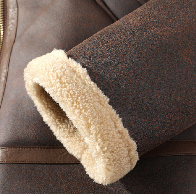 Dark brown aviator jacket close-up showing the leather sleeve seam and thick sherpa-lined cuff