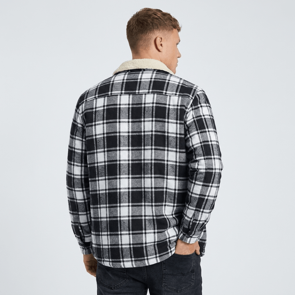 Back view of a man wearing a black and white plaid sherpa-lined overshirt jacket with a relaxed fit and long sleeves.