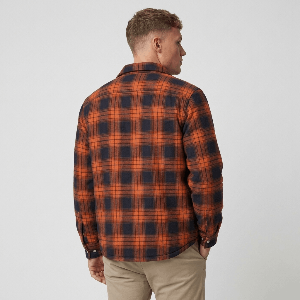 Back view of a man wearing an orange and black plaid sherpa-lined overshirt jacket with a relaxed fit.