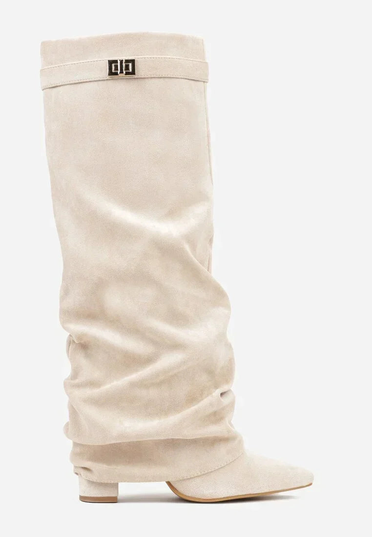 Cream suede slouchy knee-high boot with a pointed toe and small buckle detail.