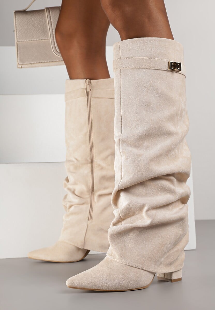 Woman wearing cream suede slouchy knee-high boots with a short outfit.
