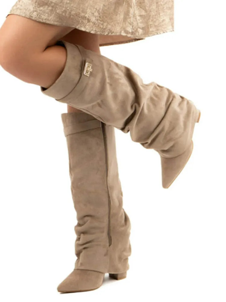 Woman wearing beige suede slouchy knee-high boots with a short dress.