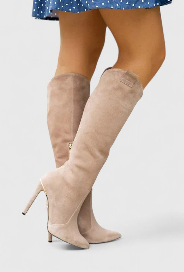 Beige suede knee-high heeled boots worn with a blue dress.