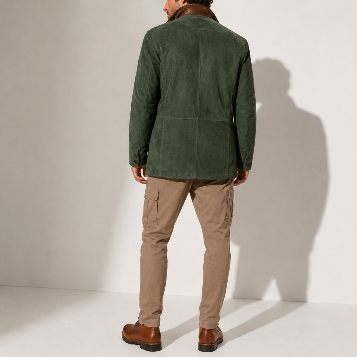 A man wearing a green suede blazer jacket with a stand collar, tailored fit, and button front, back view
