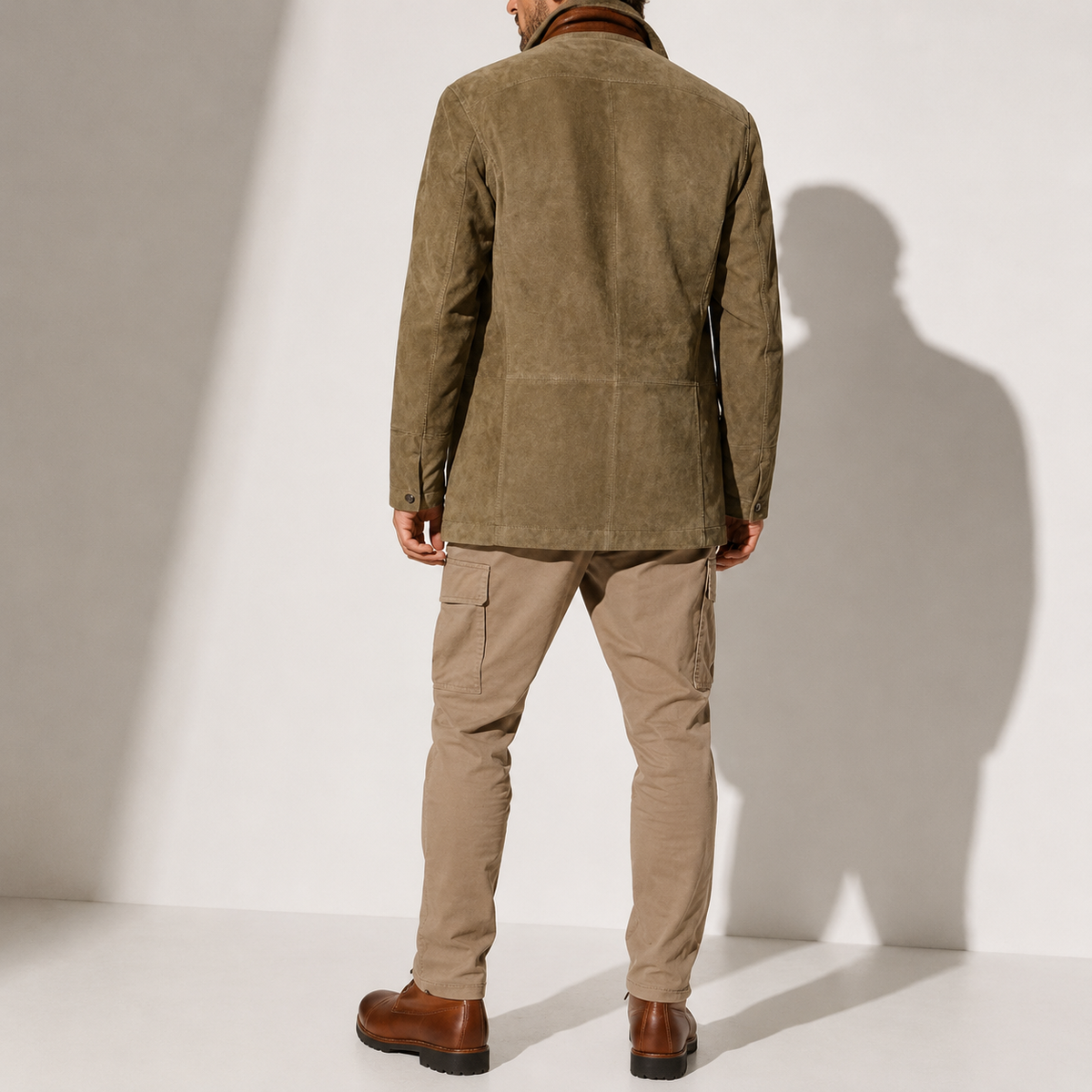 A man wearing an olive brown suede blazer jacket with a stand collar, tailored fit, and button front, back view