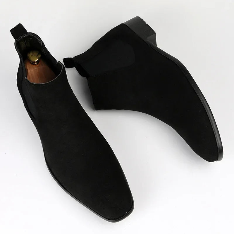Black suede Chelsea boots with a modern square toe, elastic side gussets, and a low block heel on a white background.