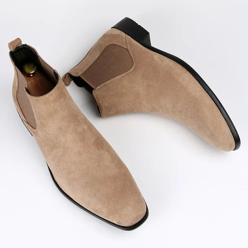 Beige suede Chelsea boots with a modern square toe, elastic side gussets, back pull tabs, and low black block heels.