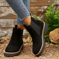 Black suede Chelsea ankle boots for women with lug sole and contrast welt, worn with cropped jeans
