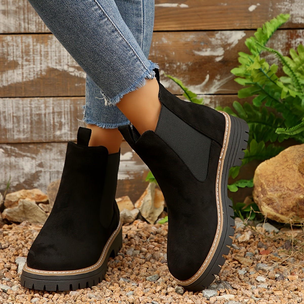Black suede Chelsea ankle boots for women with lug sole and contrast welt, worn with cropped jeans