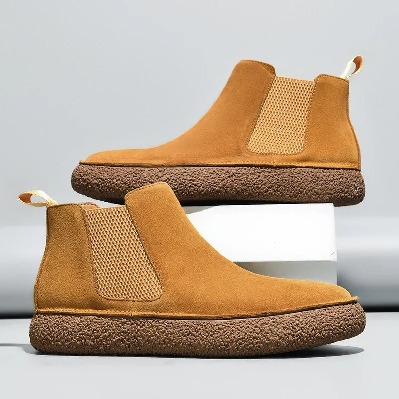 Pair of tan Chelsea boots with elastic side panels, pull tabs, and thick textured soles.