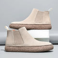 Beige suede Chelsea sneaker boots with knit gore panels, heel pull tabs, and thick, textured brown rubber outsoles.